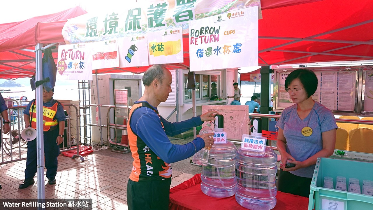 A participant is refilling his water at the water refilling station